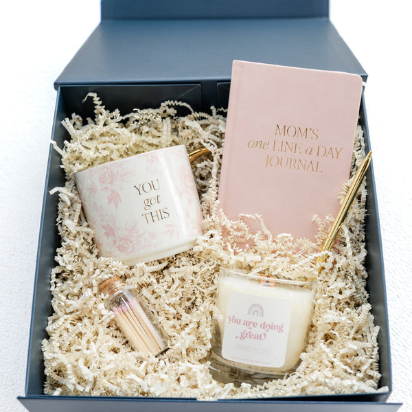 Gift set with candles and a journal in a box on a white background